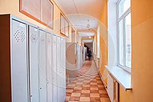 Gray metal outdated lockers in the empty school corridor of the old school