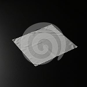 A gray microfiber cleaning cloth with a rectangular shape and zigzag edges is placed
