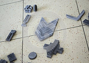 Gray models printed on 3D printer from polyamide powder on surface close-up.