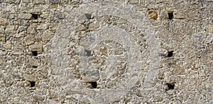 gray monochrone texture of an anciant old castle wall with little windows embrasures