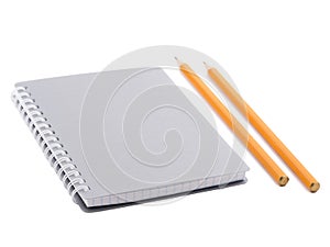 A notepad with spiral binding of sheets and two sharp pencils . Isolated on white background.