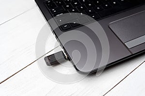 Gray open laptop computer with flash drive in the connector.