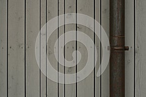 Gray painted wood boards wall. Wooden texture background, wallpaper. Metall rainpipe
