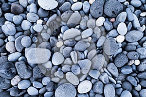 Gray pebbles as a background. Round stones on the beach. Photography for design