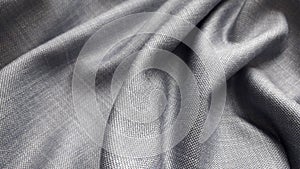 Gray plain weave suiting fabric with a sheen. The texture of the fabric.