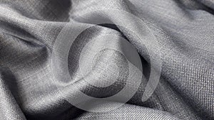 Gray plain weave suiting fabric with a sheen. The texture of the fabric.