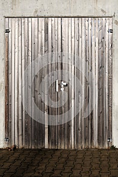 Gray planks of a wooden door in concrete wall