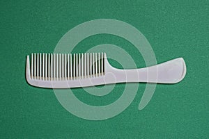 gray plastic comb lies on a green table