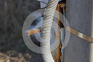 Gray plastic hose on a concrete pole