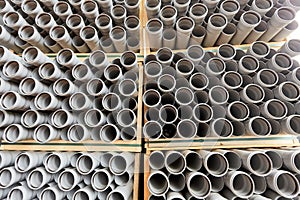 Gray plastic pipes lie in rows