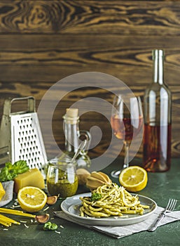 Gray plate of spaghetti pasta bucatini with pesto sauce and parmesan. Italian traditional perciatelli pasta by genovese pesto