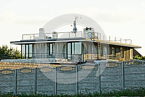 Gray private house behind a concrete fence