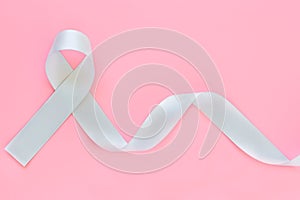 Gray ribbon on pink isolated background copy space. Brain Cancer Awareness, Brain Tumors, Allergies, Asthma, Diabetes Awareness,