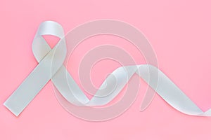 Gray ribbon on pink isolated background copy space. Brain Cancer Awareness, Brain Tumors, Allergies, Asthma, Diabetes Awareness, photo