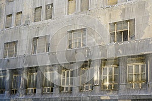 Gray safety net around a large abandoned townhouse in poor condition, grey protective coating