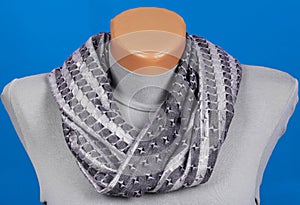 Gray scarf on mannequin isolated on blue background.