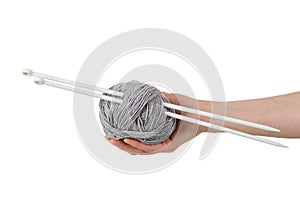 Gray skein of woolen threads and knitting needles in female hand isolated on a white