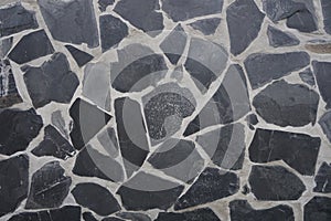 Gray slate rock plate on cement wall background