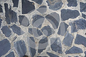 Gray slate rock plate on cement wall background