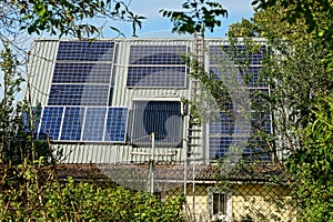 Gray slate roof of a private house with blue solar panels