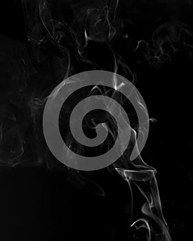 Gray smoke on a black background. Realistic incense smoke captured with a flash