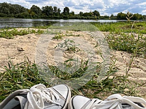 gray sneakers in summer on a snag on the background of a beach