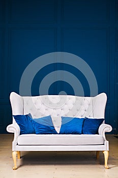 Gray sofa with blue pillows on blue background