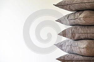Gray sofa pillows stacked in a pile.