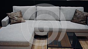 Gray sofa with two brown leather pillows. Black coffee table. 4k video.