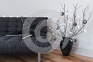 Gray sofa, winter decorations and cozy lights