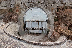 Gray stone road going down to a cellar