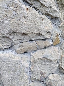 Gray stone wall background, mosaic stonewall rubble facade closeup texture