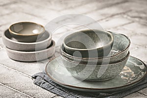 Gray stoneware plates and bowls on a rustic table