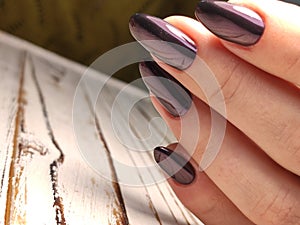 Gray striped nail design on female hand close up