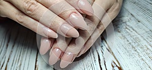 Gray striped nail design on female hand close up