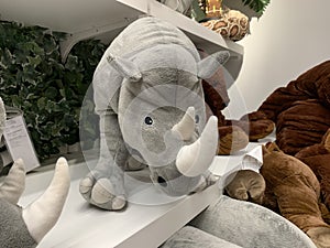 Gray stuffed toy rhino on a shelf