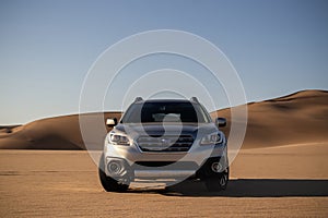 Gray Subaru in the sand of the Namib desert at a bright sky. Namibia