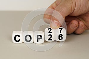 On a gray surface are white cubes with the inscription - COP26 to COP27