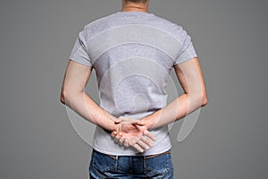 Gray t-shirt on a young man template. Back view. Gray background