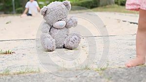 Gray teddy bear sitting lonely on the playground, concept of loss of parents, loneliness of children, caring for orphans