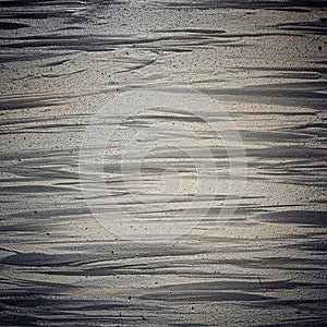 Gray textured surface featuring horizontal brush strokes, creating an abstract pattern.
