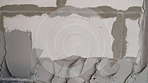 Gray wall of foam blocks on glutinous solution. Application of the solution to the wall from foam blocks