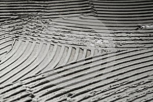 Gray wall glue plaster comb surface prepared for tiling. Tile adhesive notched trowel patterns. Texture background of