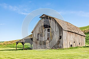 A gray weathered barn in the Palouse hills