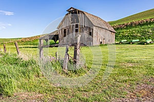 A gray weathered barn in the Palouse hills