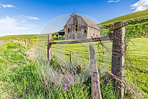 A gray weathered barn in the Palouse hills