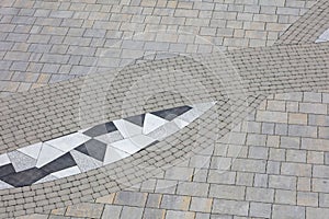 A gray and white tile pattern with a black and white triangle