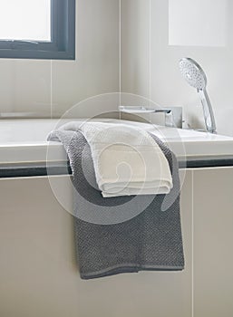 Gray and white towel and bathtub in modern interior bathroom