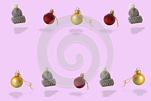 Gray woolen cap whit white pompon and Christmas baubles pattern on pink