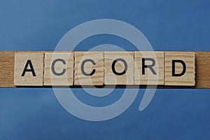 Gray word accord in small square wooden letters